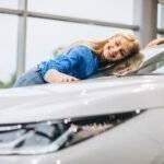 Mulher junto a um automóvel bem cuidado